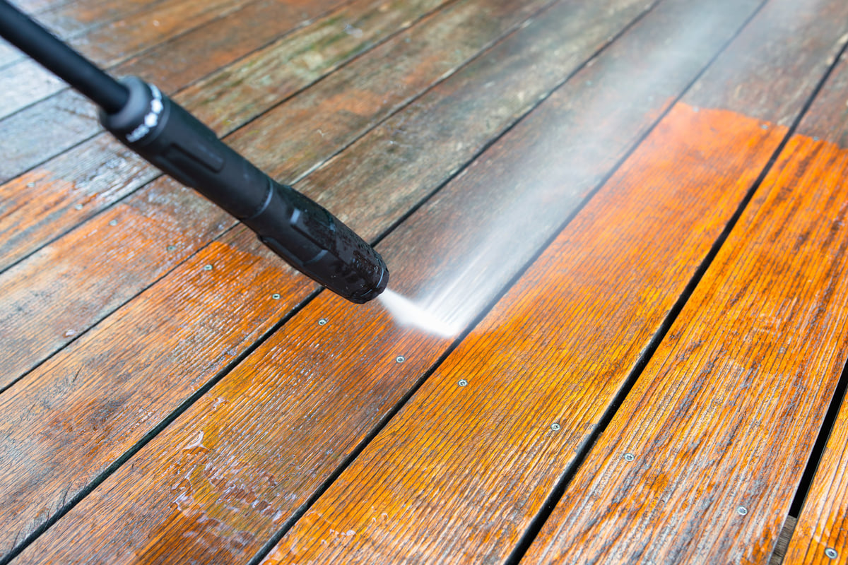 Cleaning a wooden terrace deck with a pressure washer